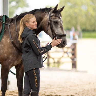 Buy the Shires Aubrion Young Rider Black Team Waterproof Jacket | Online for Equine